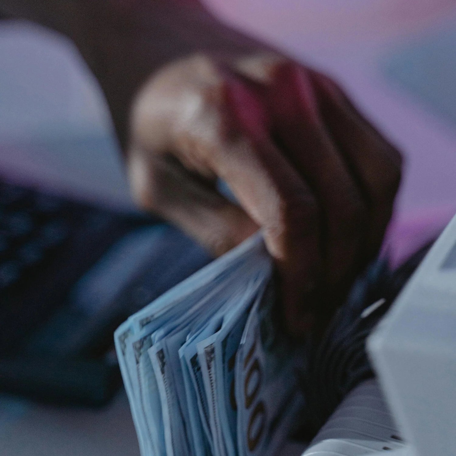 Hand counting money with a blurred background

